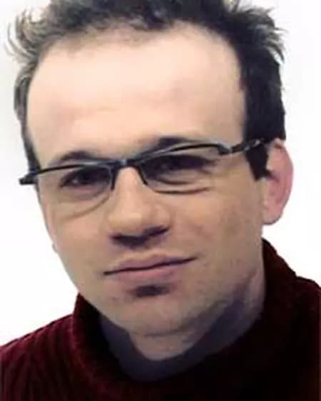 Benoît Chesneau, head and shoulders, wearing glasses and a dark red roll neck